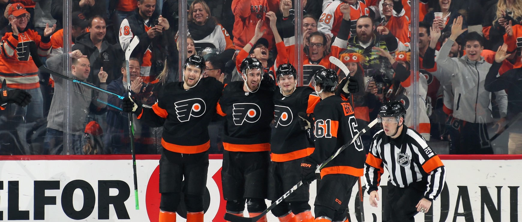 Shayne Gostisbehere, Claude Giroux, Nolan Patrick, and Sean Couturier celebrating together on the ice during a game night at the Wells Fargo Center