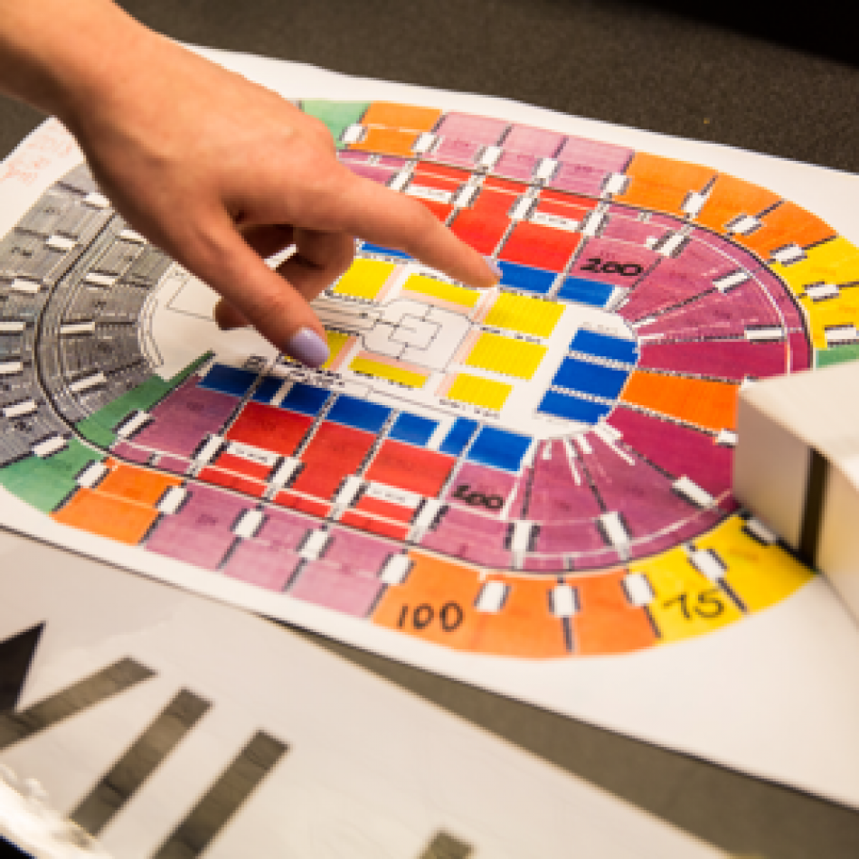 Woman’s hand pointing to a seating map of the Wells Fargo Center